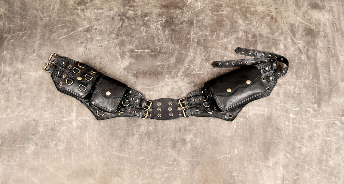 Black leather utility belt bag with three flap pockets and antique brass-tone hardware.