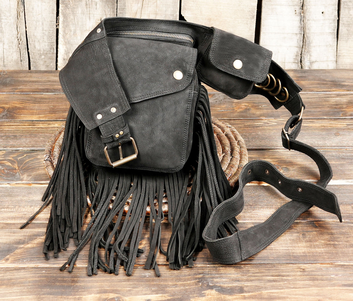 Close up of black leather fringe fanny pack pockets