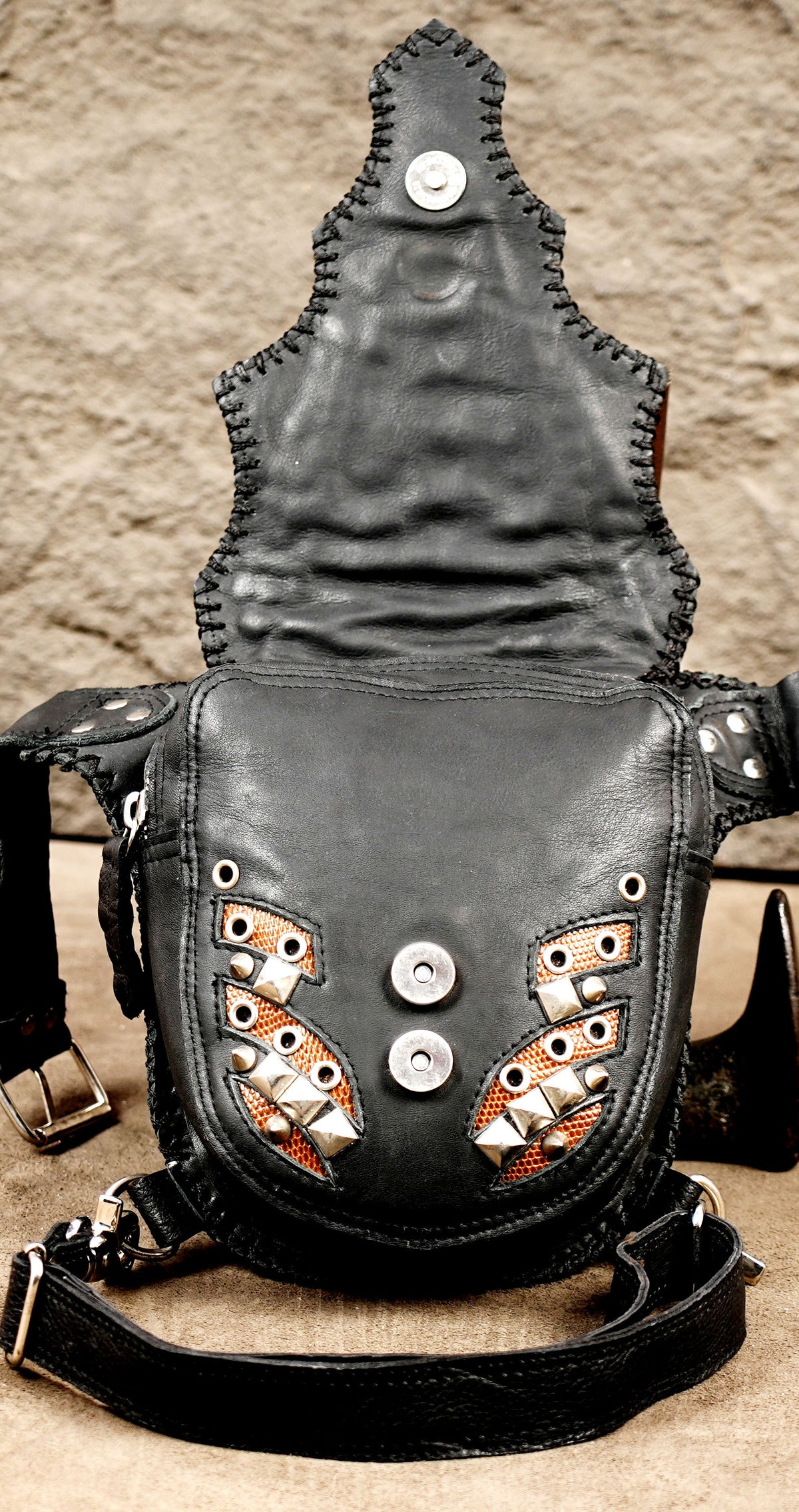 Adjustable black leather belt with silver buckle on a hip bag