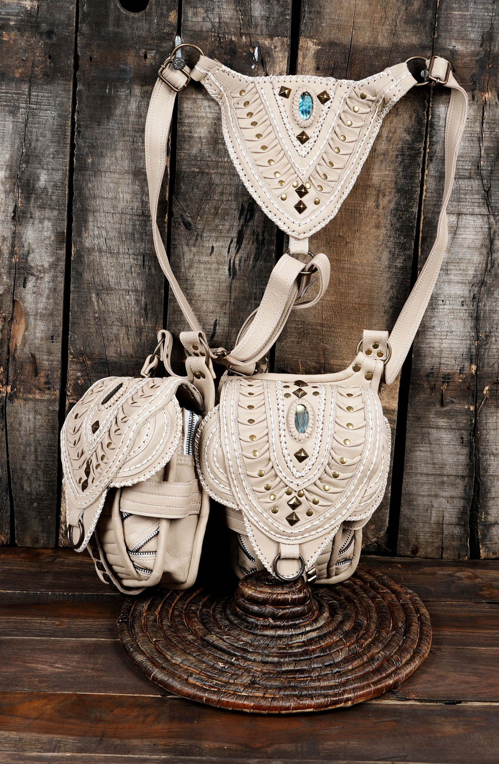 Versatile off-white leather shoulder holster harness featuring two decorated utility pouches.