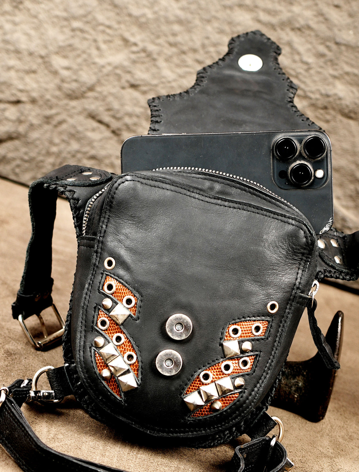 Close-up of copper mesh and metal studs on a leather bag