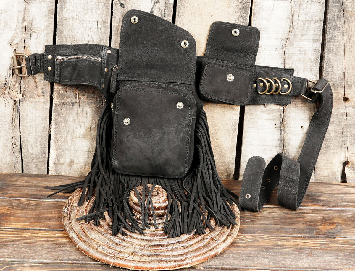Rustic black leather fringe belt bag on wooden background