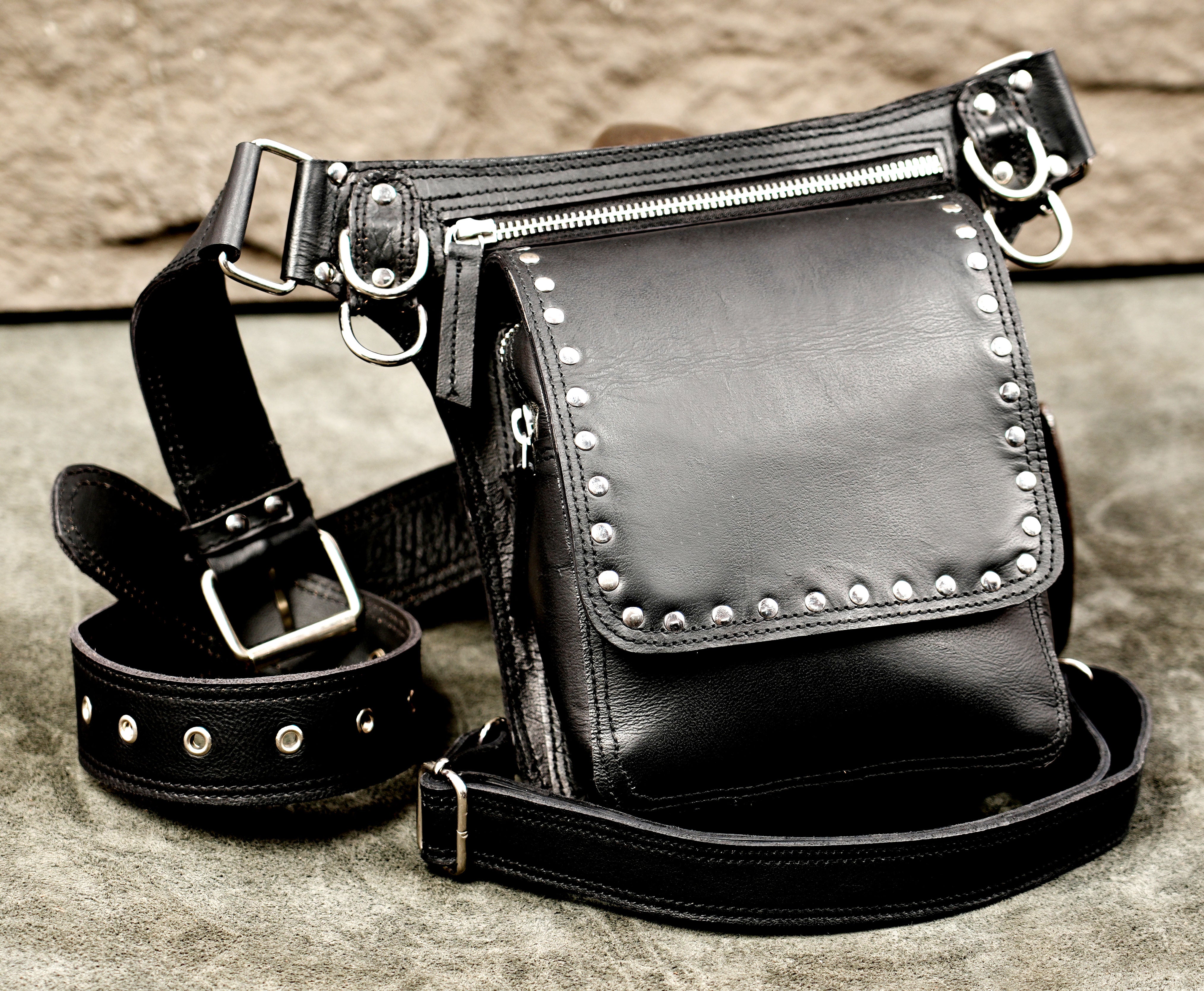 Multi-strap black leather leg bag featuring silver hardware and rivets.