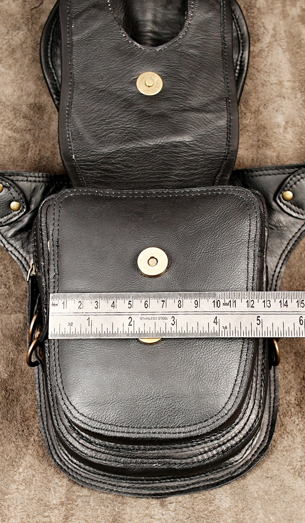 Black leather holster bag with detailed embroidery, braids, and brass fittings.