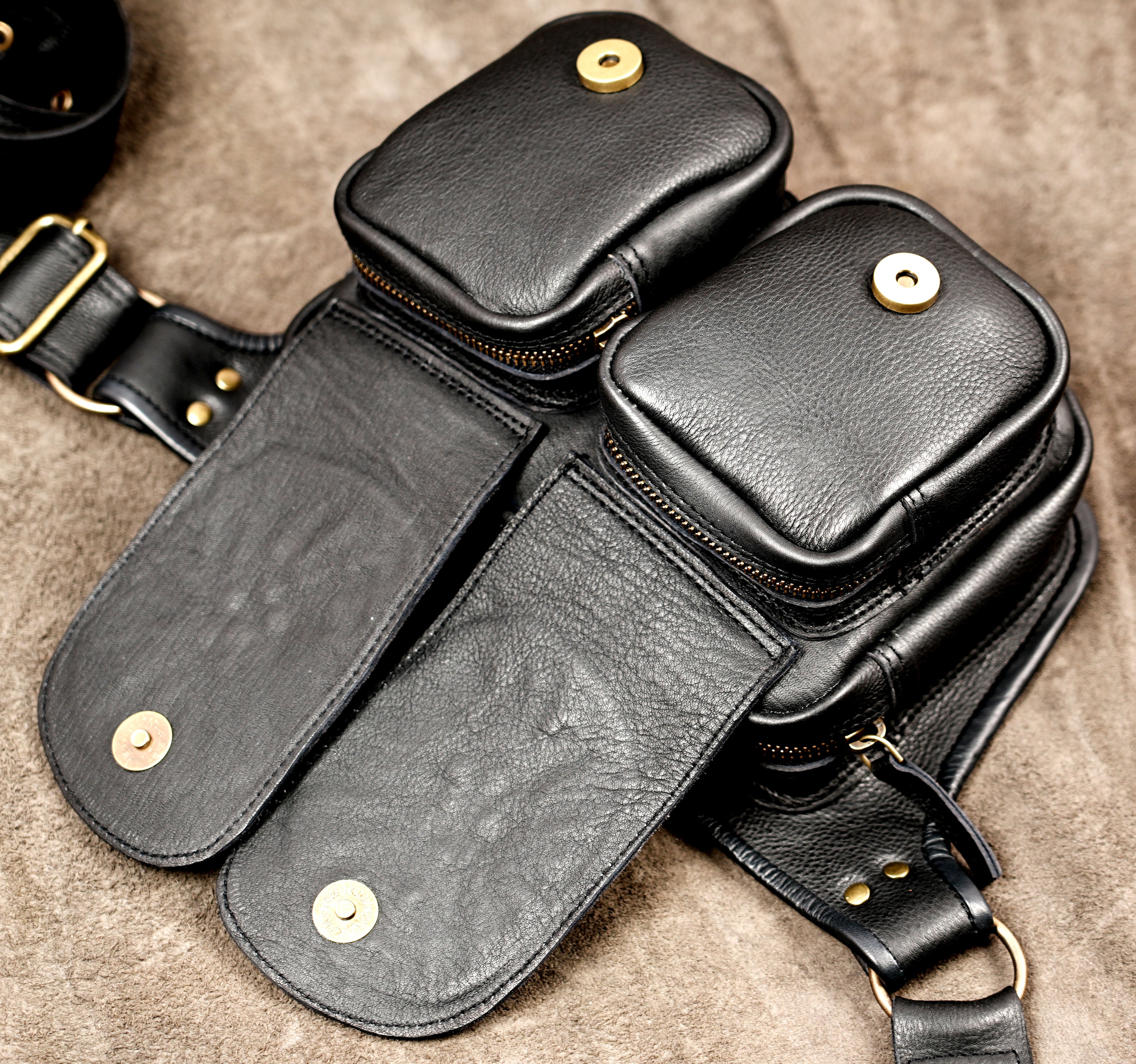 Unisex black leather waist belt featuring two compact pouches and floral flap designs.