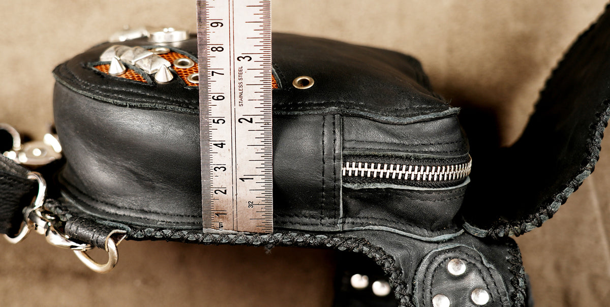 Black leather holster bag with woven flap and cone studs