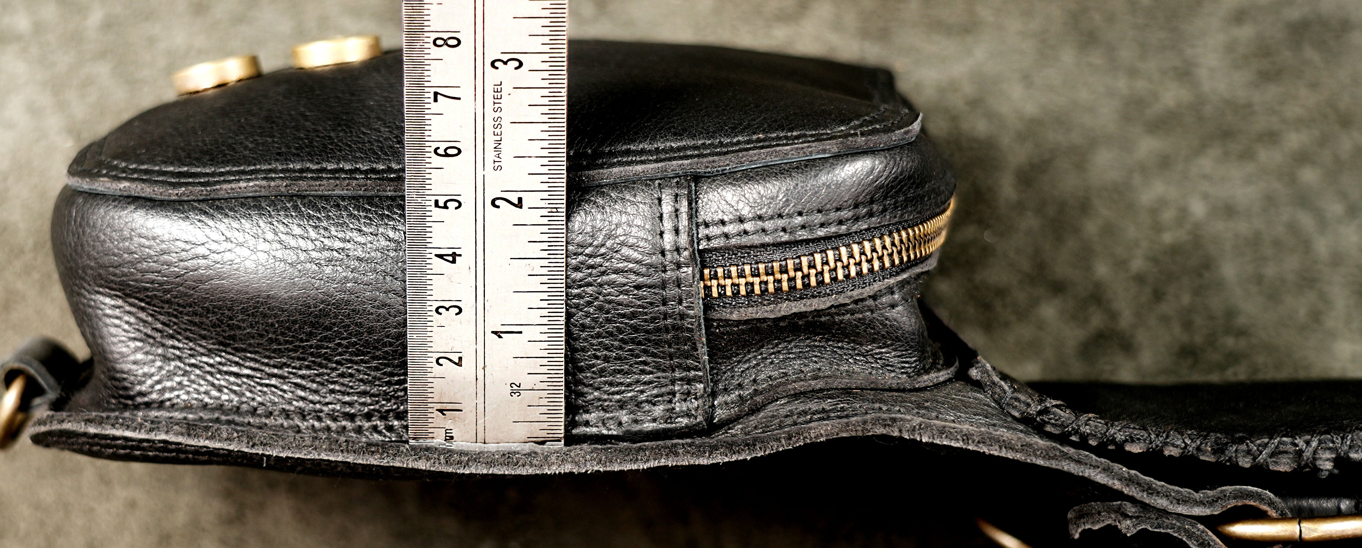 Custom-styled black leather dual pocket holster harness with intricate embossed patterns and sturdy hardware