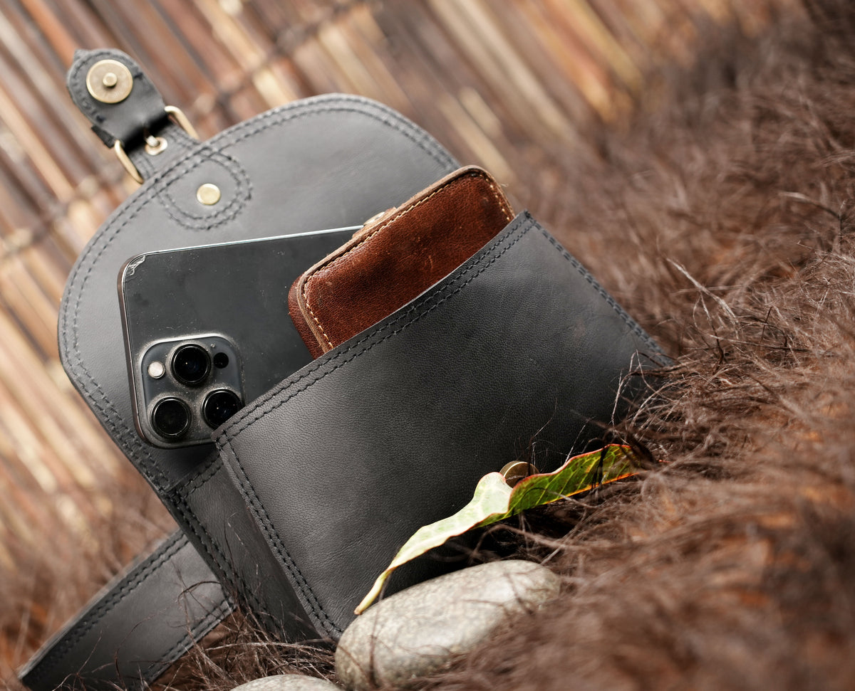 Adjustable black leather belt bag with a rectangular pouch and rounded corners.