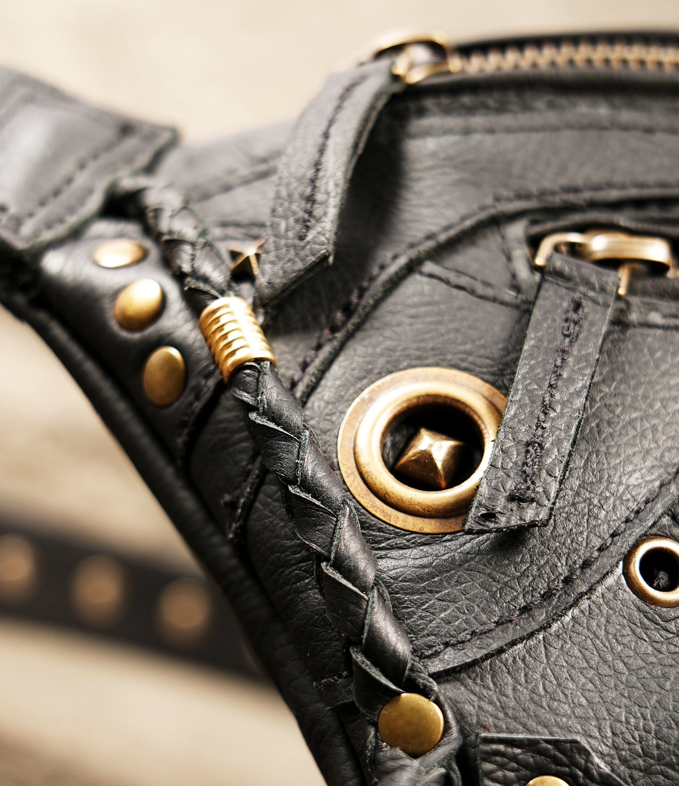 Black leather motorcycle hip pouch with heavy-duty brass hardware.