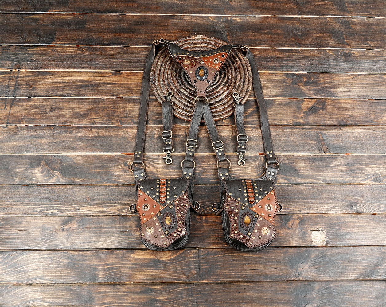 Handmade leather holster belt with dual utility pouches on wooden background