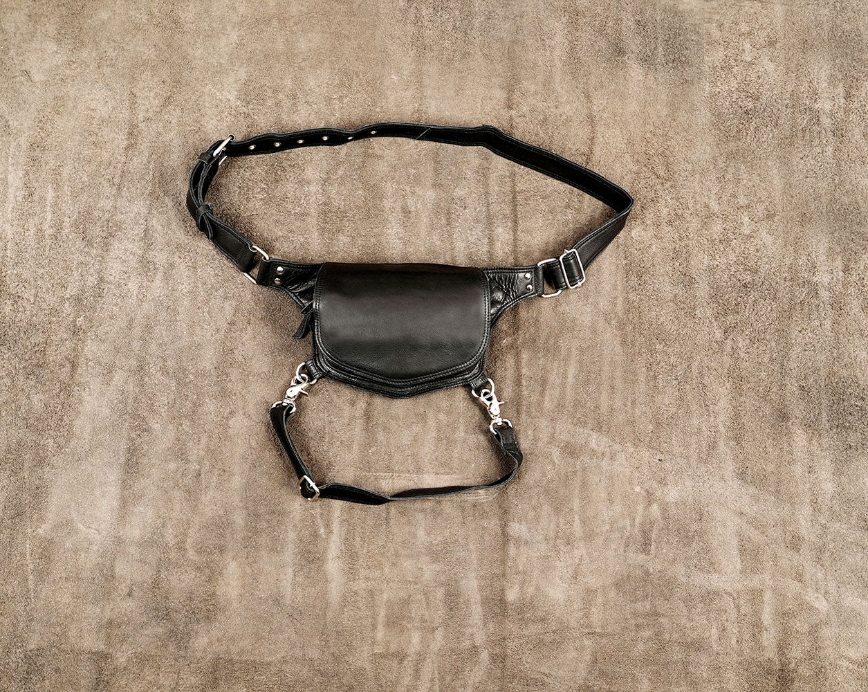Black leather drop leg bag styled for bohemian music festivals and outdoor raves in the US and Europe