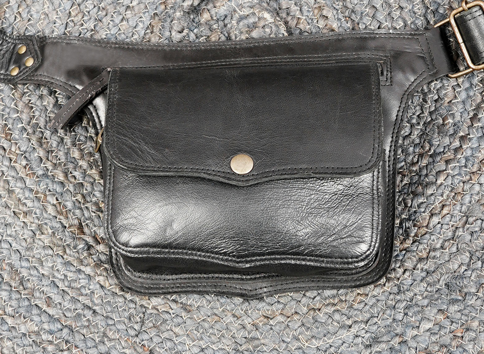 Handmade leather waist belt featuring secure snap button pocket