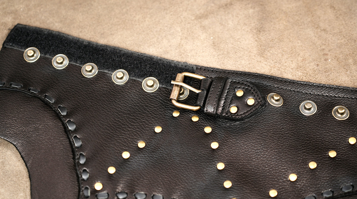Handmade dark brown leather skirt with black stitching and metal ring details