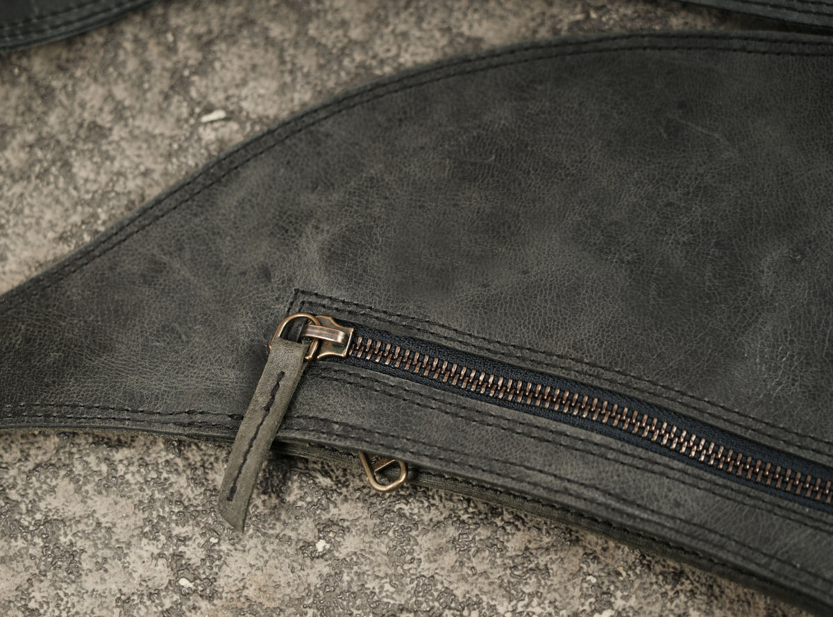 Leather shoulder holster with front zipper pockets and metal hardware