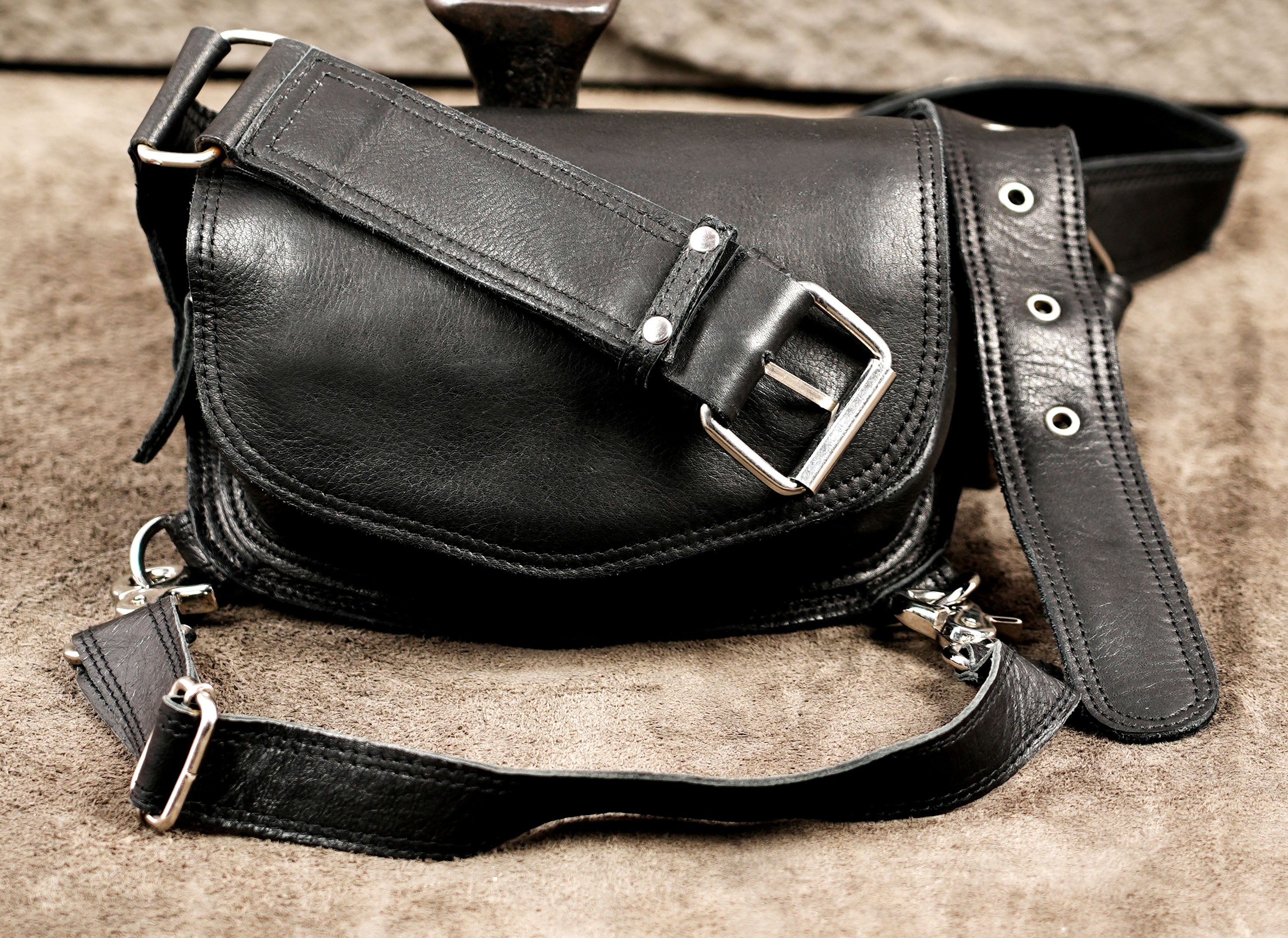 Stylish black leather waist pack with a detachable leg strap for easy day-to-night transitions