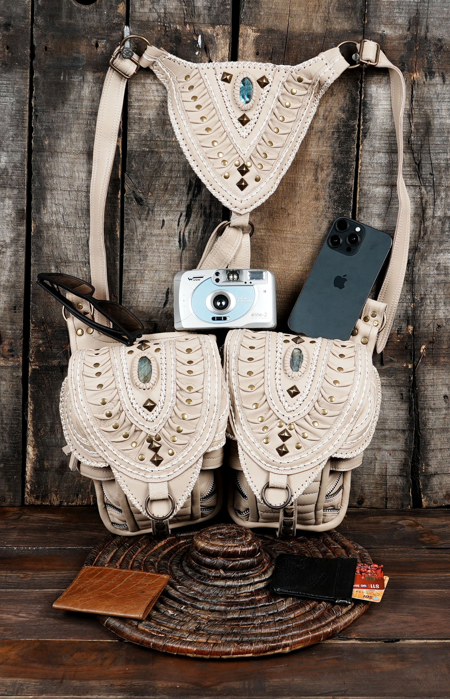 Close-up of embroidered off-white leather shoulder holster bag with a gemstone center.