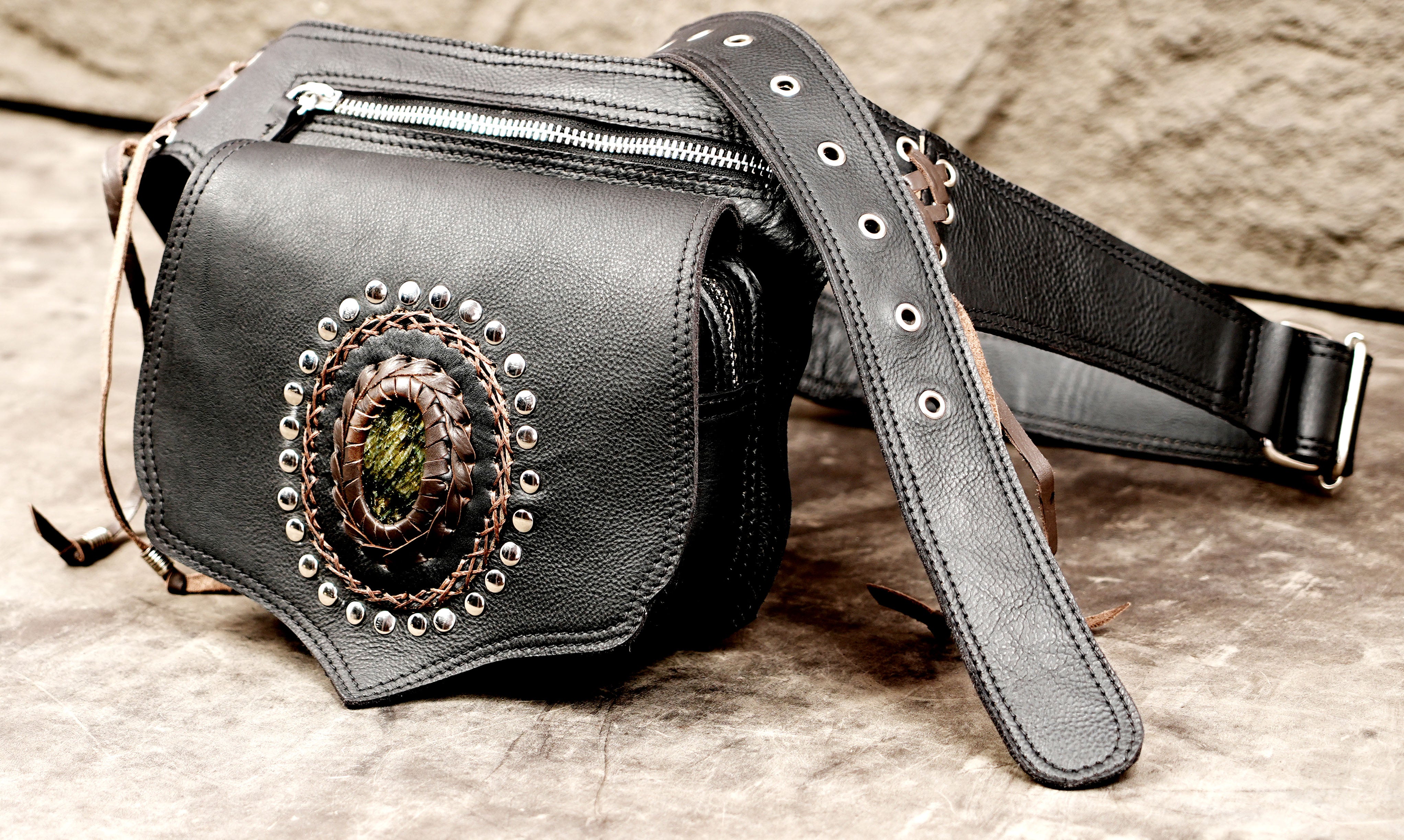 Cowhide leather utility belt bag with decorative eyelets, lacing, and a focal gemstone.