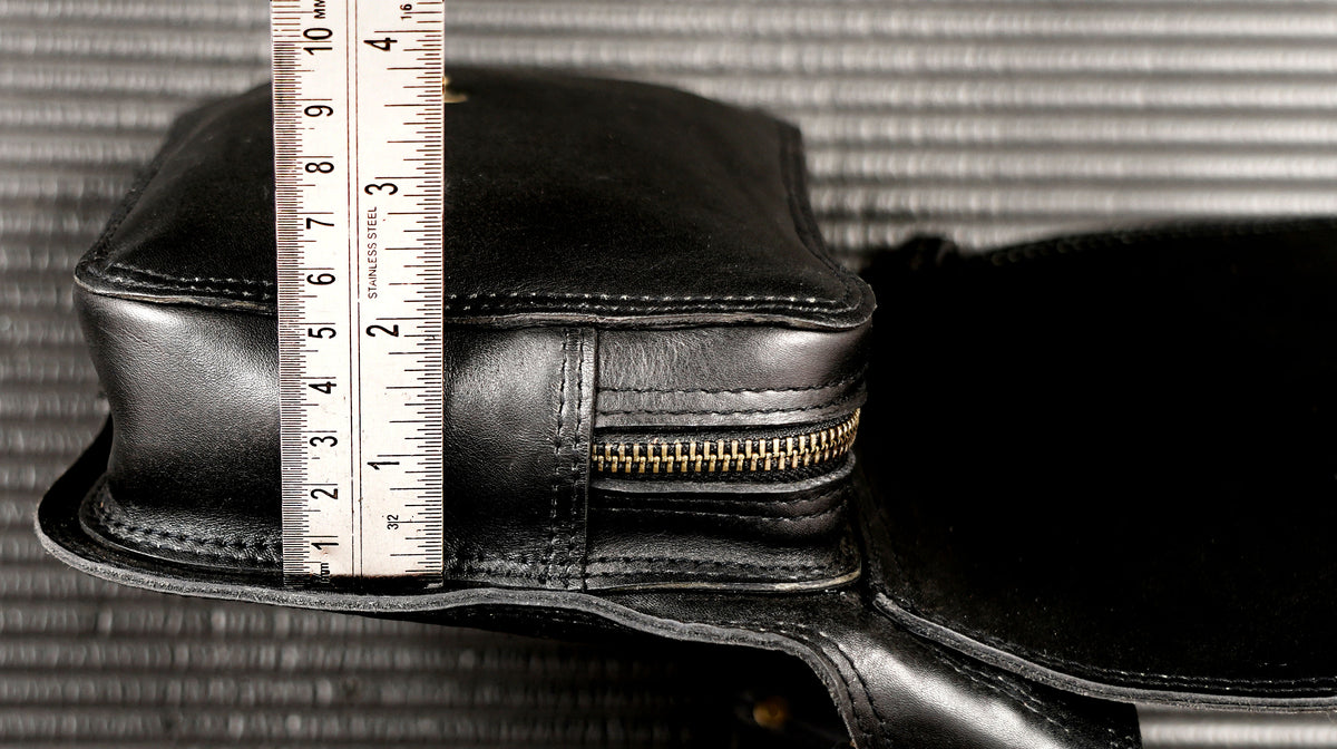 Adjustable black leather belt pouch laid flat, full strap visible