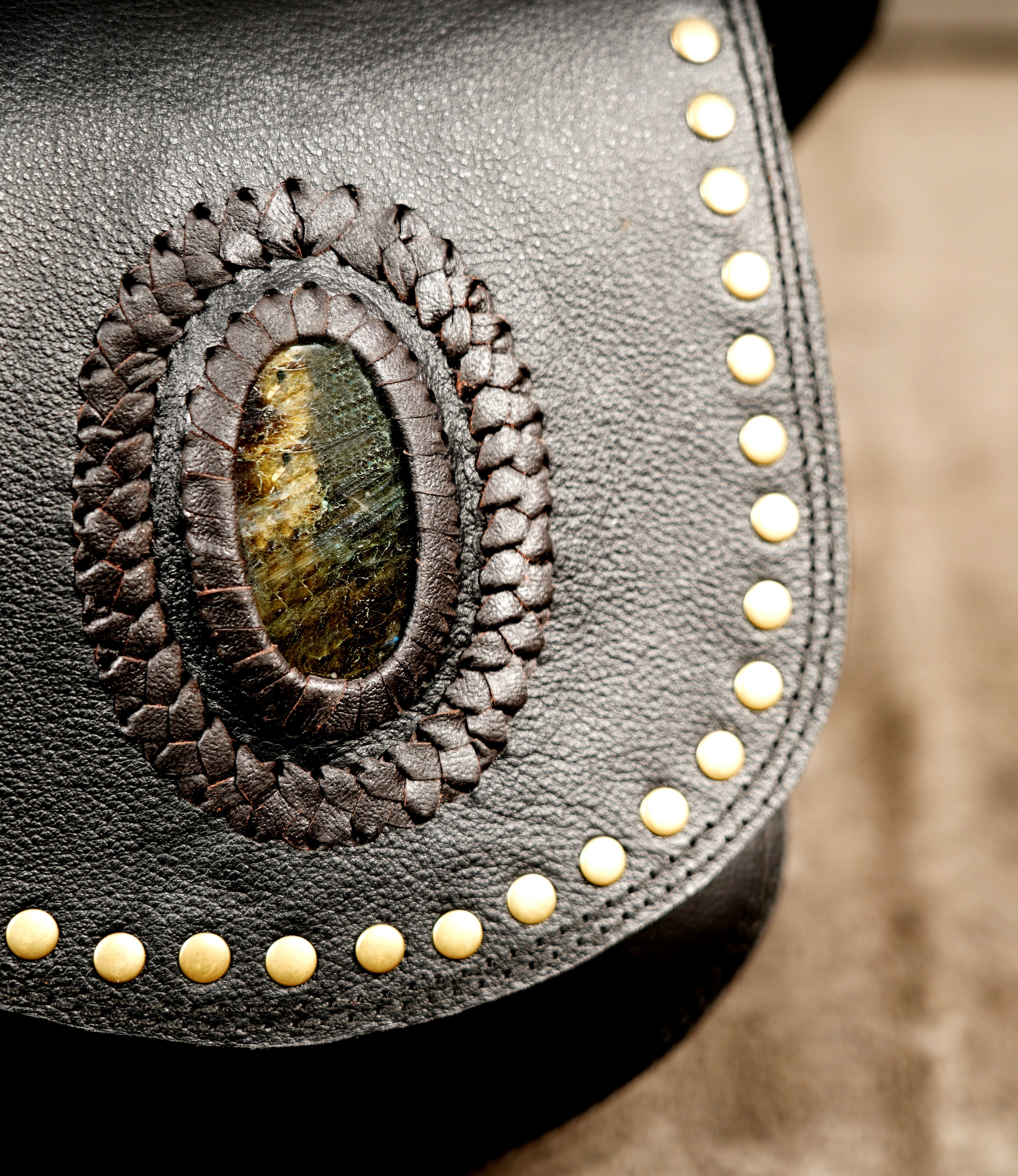 Adjustable leather belt bag with gemstone flap, flat lay view