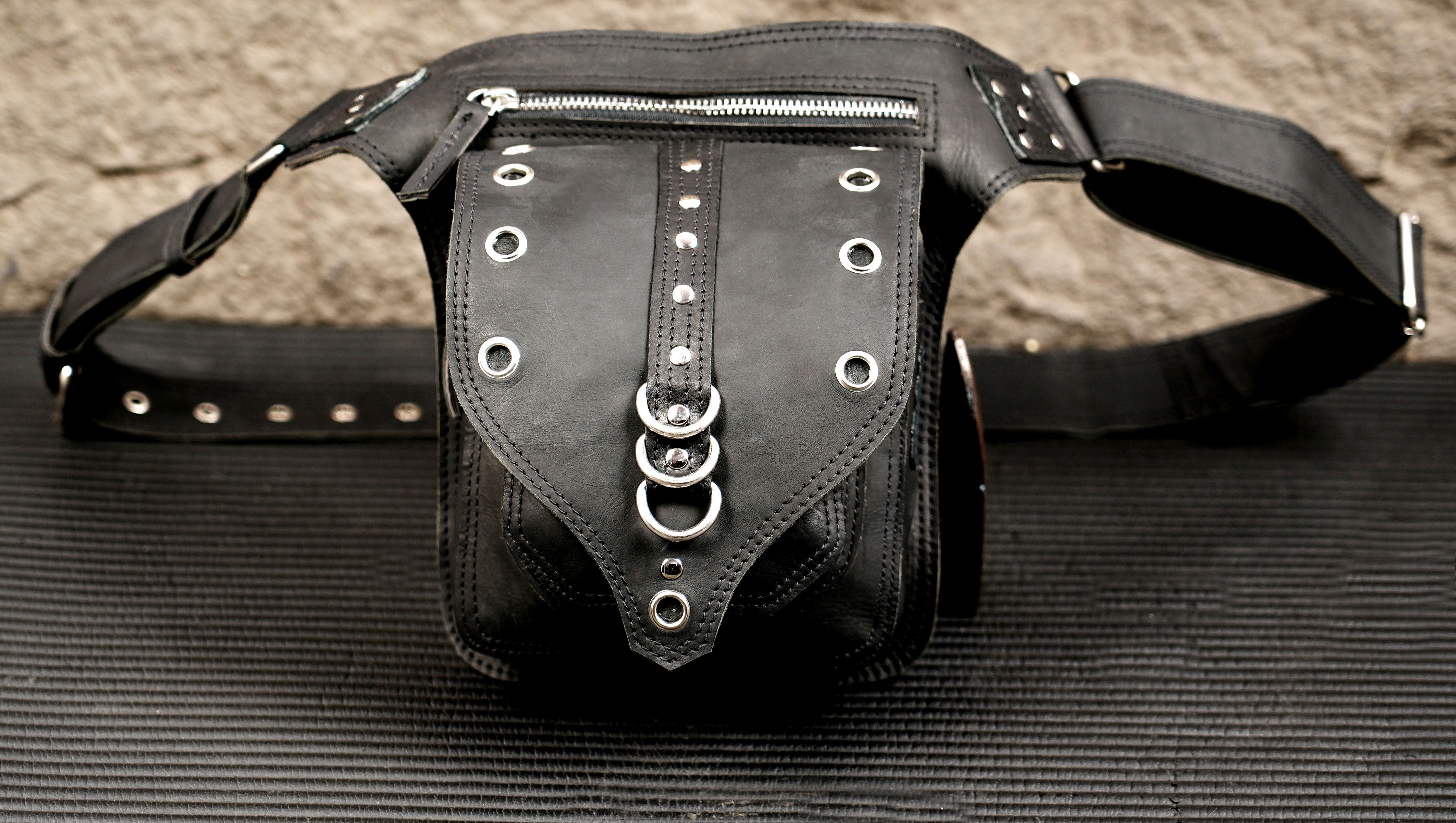 Artisan-made black leather waist bag with antique brass fittings