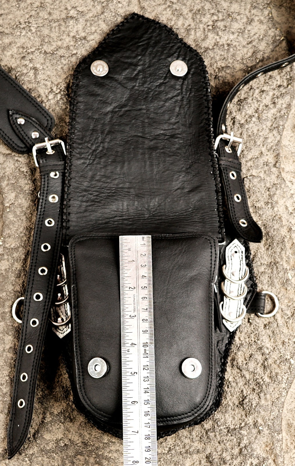 Black and white leather utility harness bag with metal clips and buckles