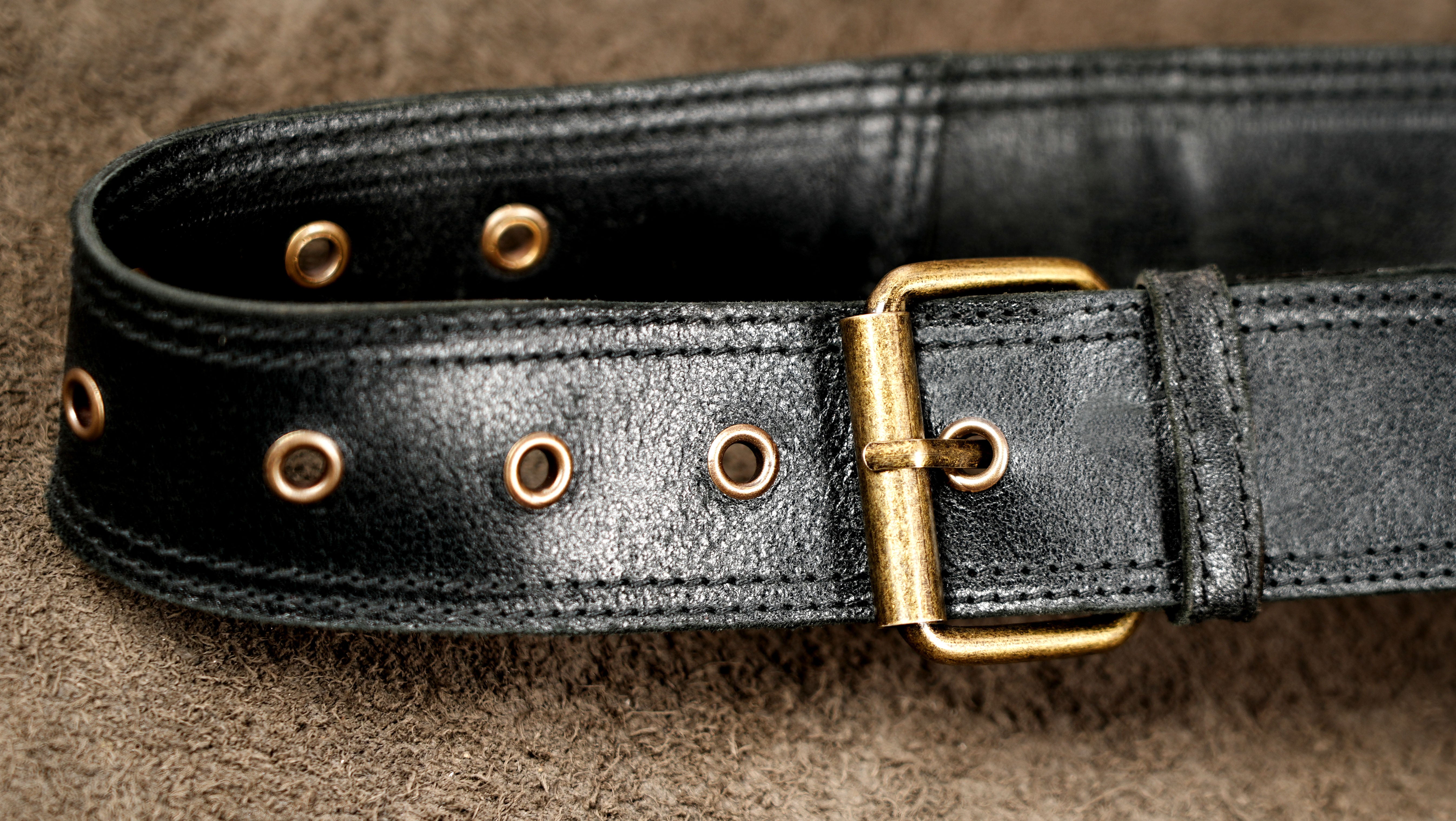 Black leather hip bag with decorative brass rings