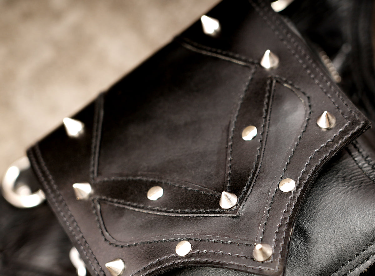 Black leather hip pouch with V stud pattern, close up