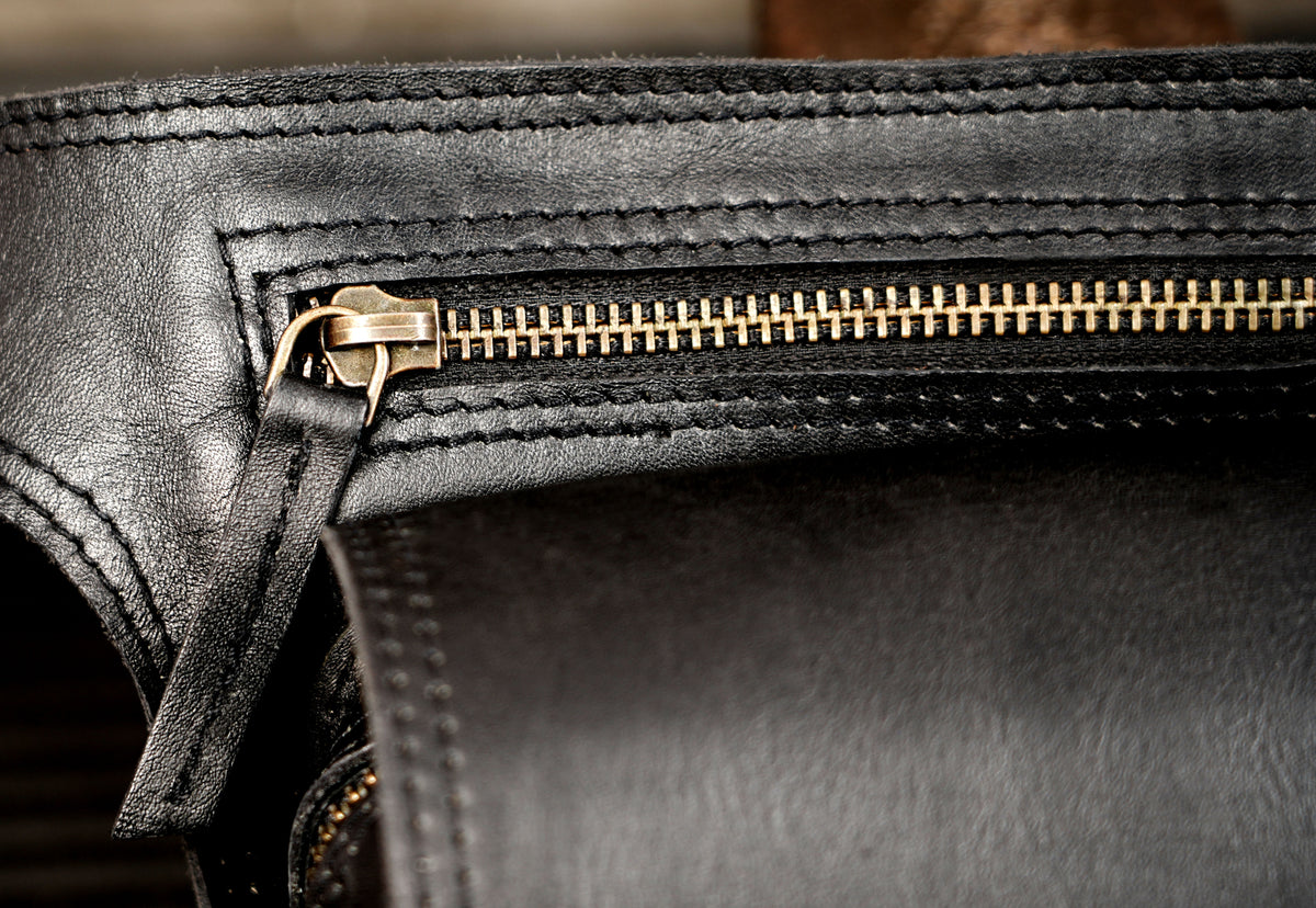 Black leather hip pouch with zipper pocket and brass eyelets