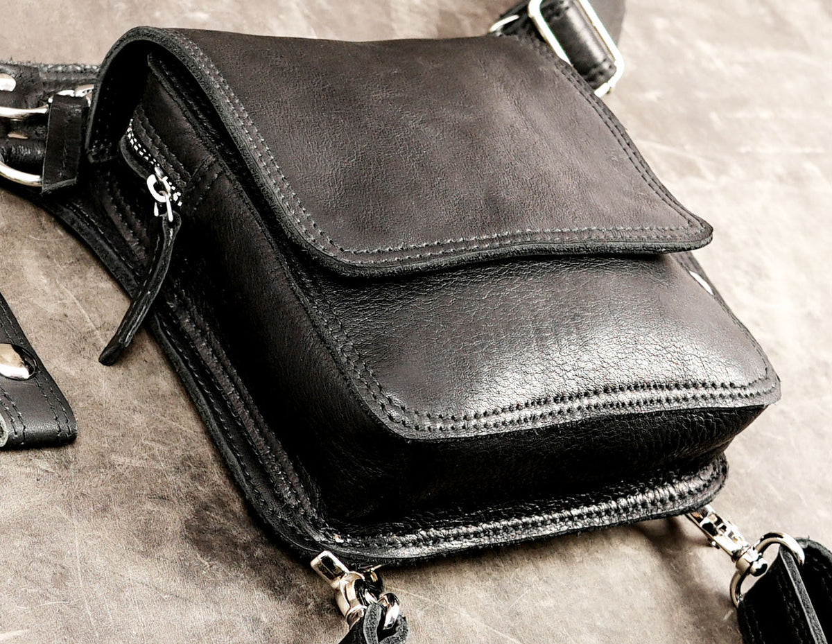 Black leather thigh bag featuring a large rectangular flap pocket