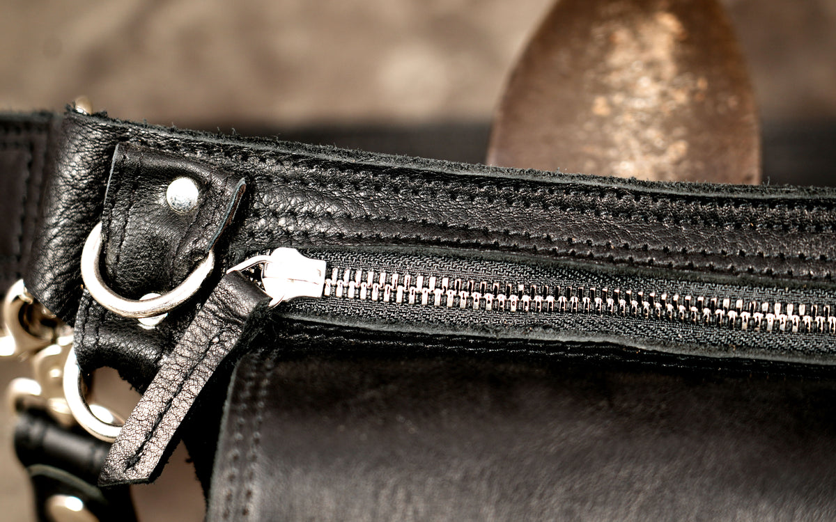 Black leather waist pack with secure flap and zipper compartments