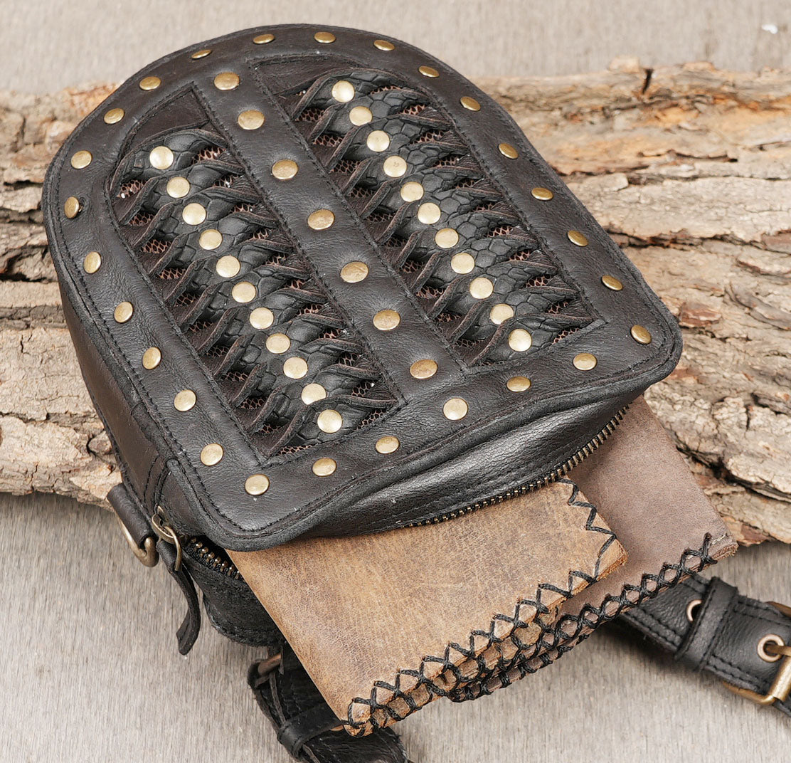 Gothic festival outfit accessory featuring black leather straps and brass studs