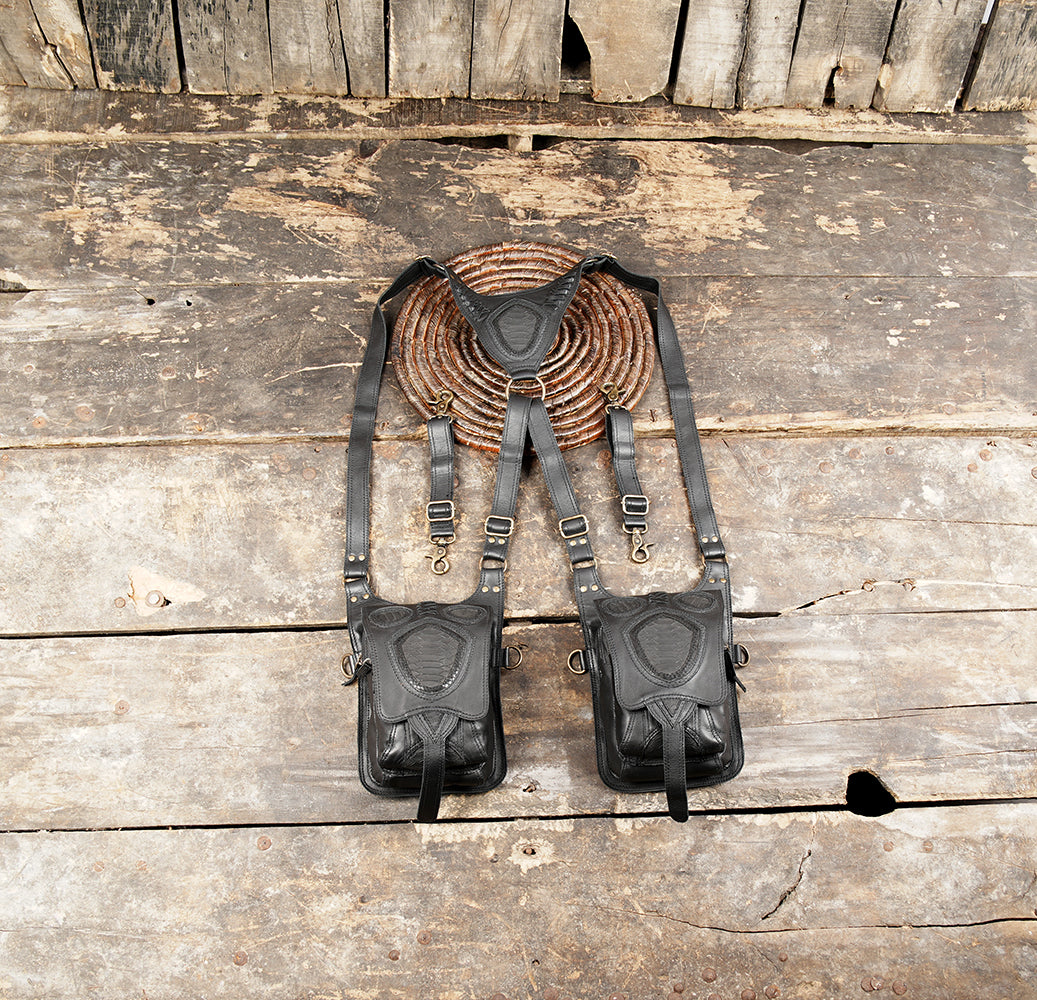 Black leather dual holster bag with adjustable shoulder harness and two utility pouches