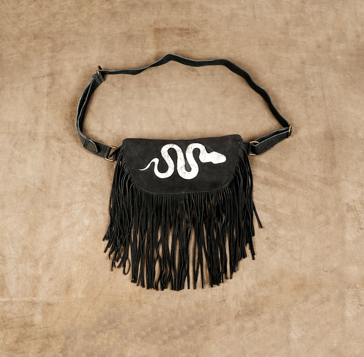 Black leather fringe waist bag with white snake design and adjustable belt for women.