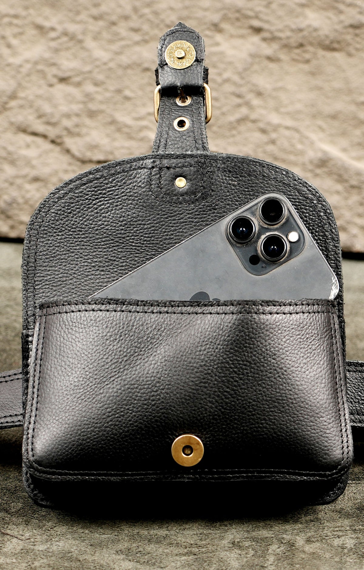 Black leather hip bag with bronze buckle and pebbled texture