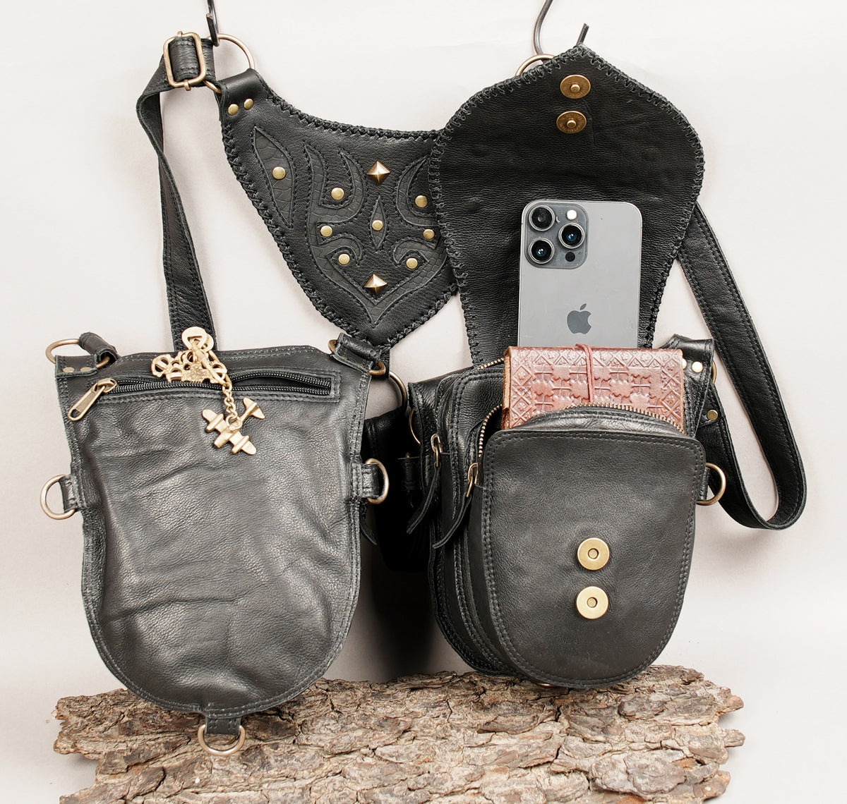 Black leather shoulder harness with two matching hip pouches and adjustable thigh holster straps for women.