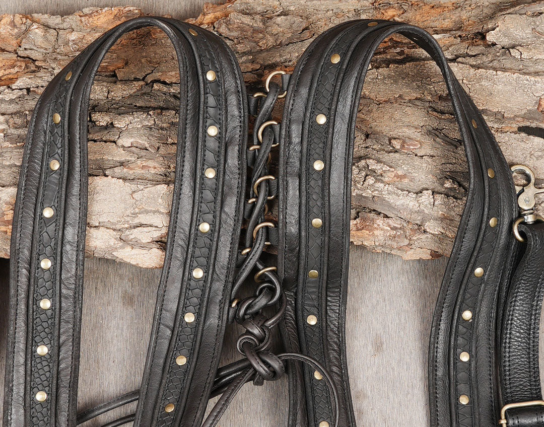 Black leather thigh accessory with studded panels and adjustable harness straps