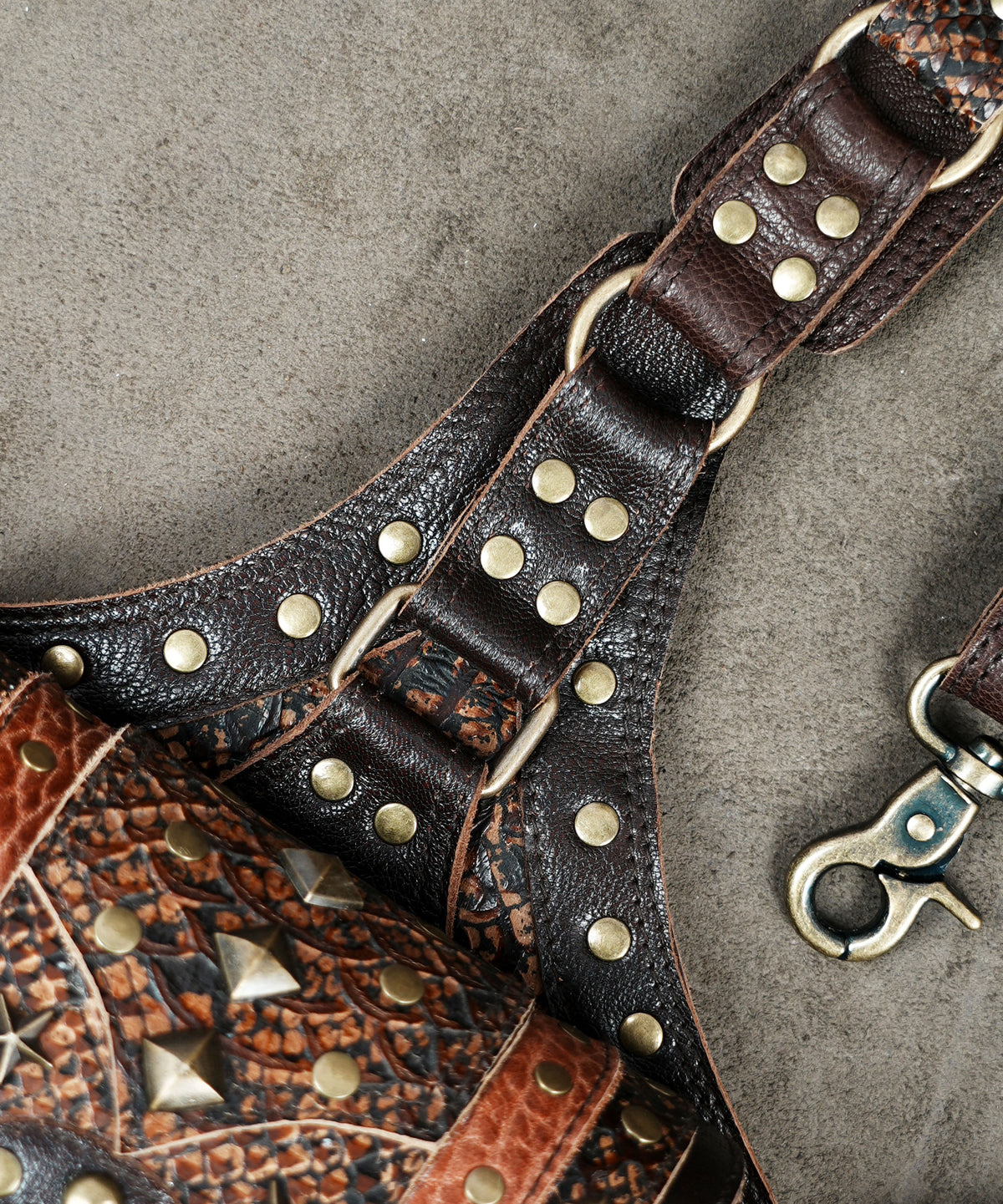 Brown leather dual pouch shoulder bag with adjustable harness straps for everyday essentials.