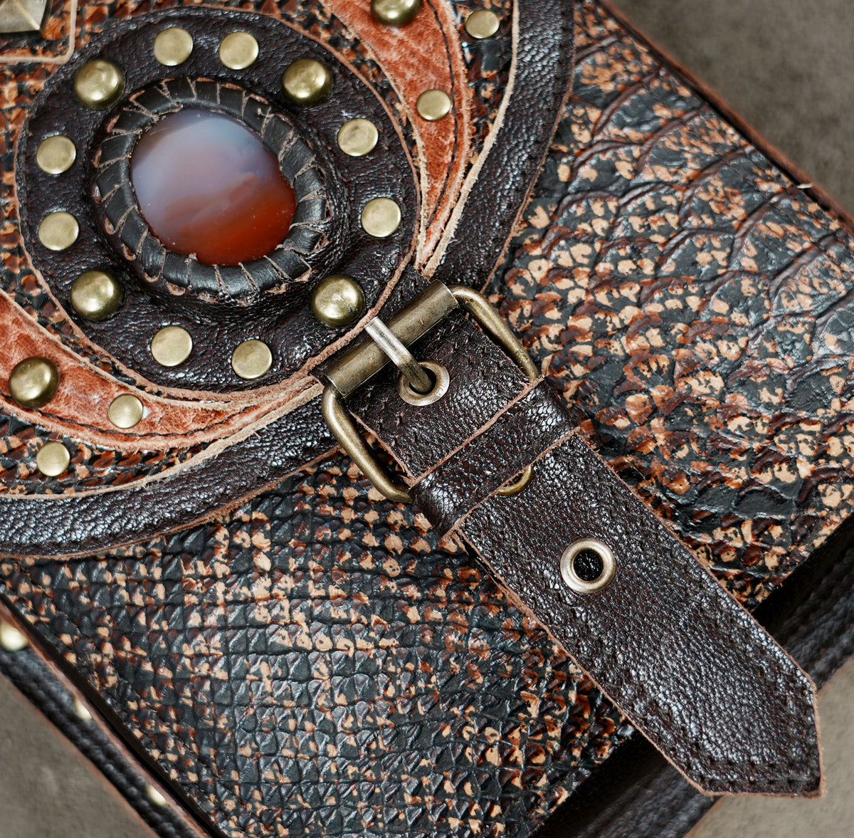 Handmade leather utility harness with two side pouches and decorative gemstone details.
