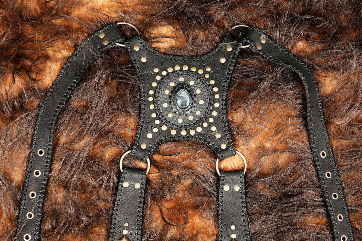 Steampunk leather double holster harness with decorative stone details and adjustable straps.