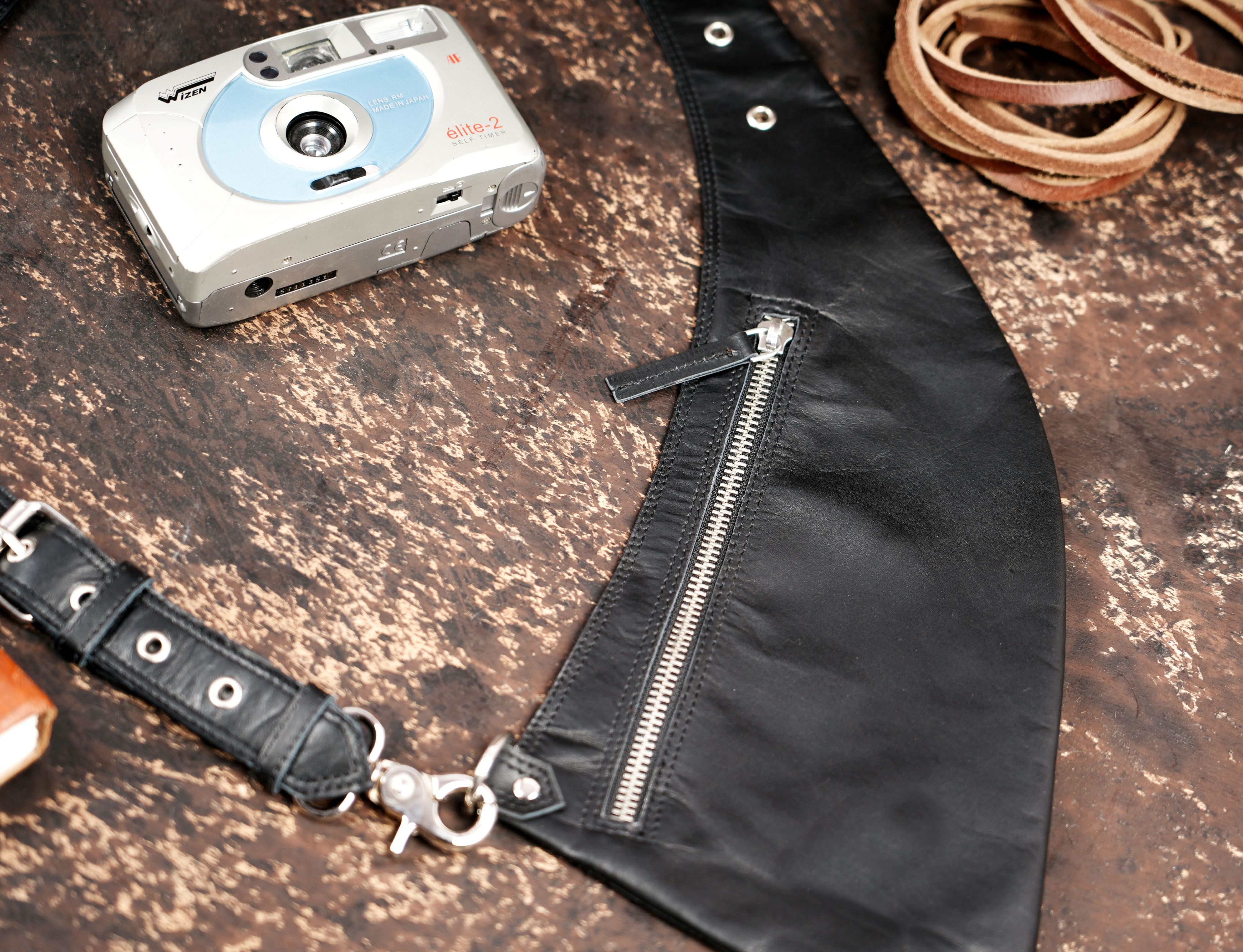 Adjustable black leather chest holster with metal rings and buckles