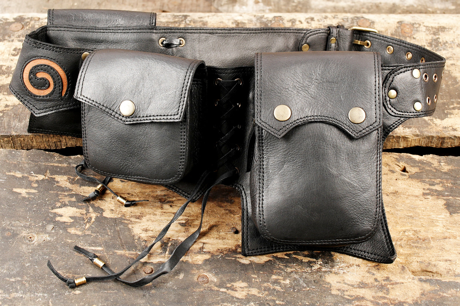 Black leather hip bag for raves and music festivals featuring secure snap pouches and brass studs.