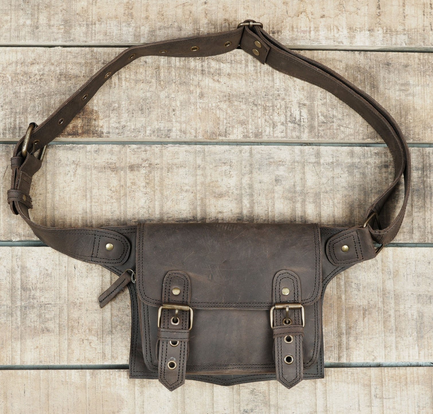 "Crossbody or waist-wear leather belt bag with buckles"