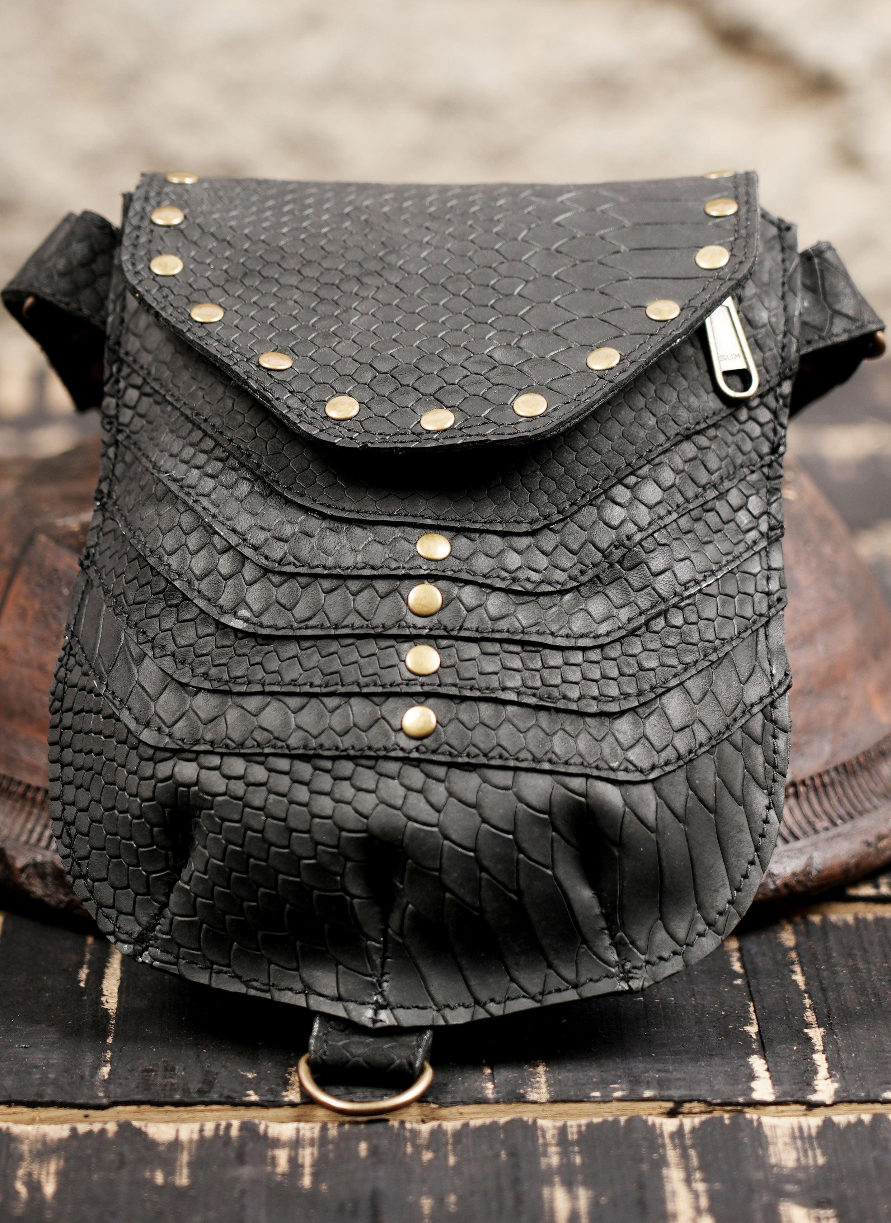 Handmade leather festival holster with snake-textured finish and stud accents