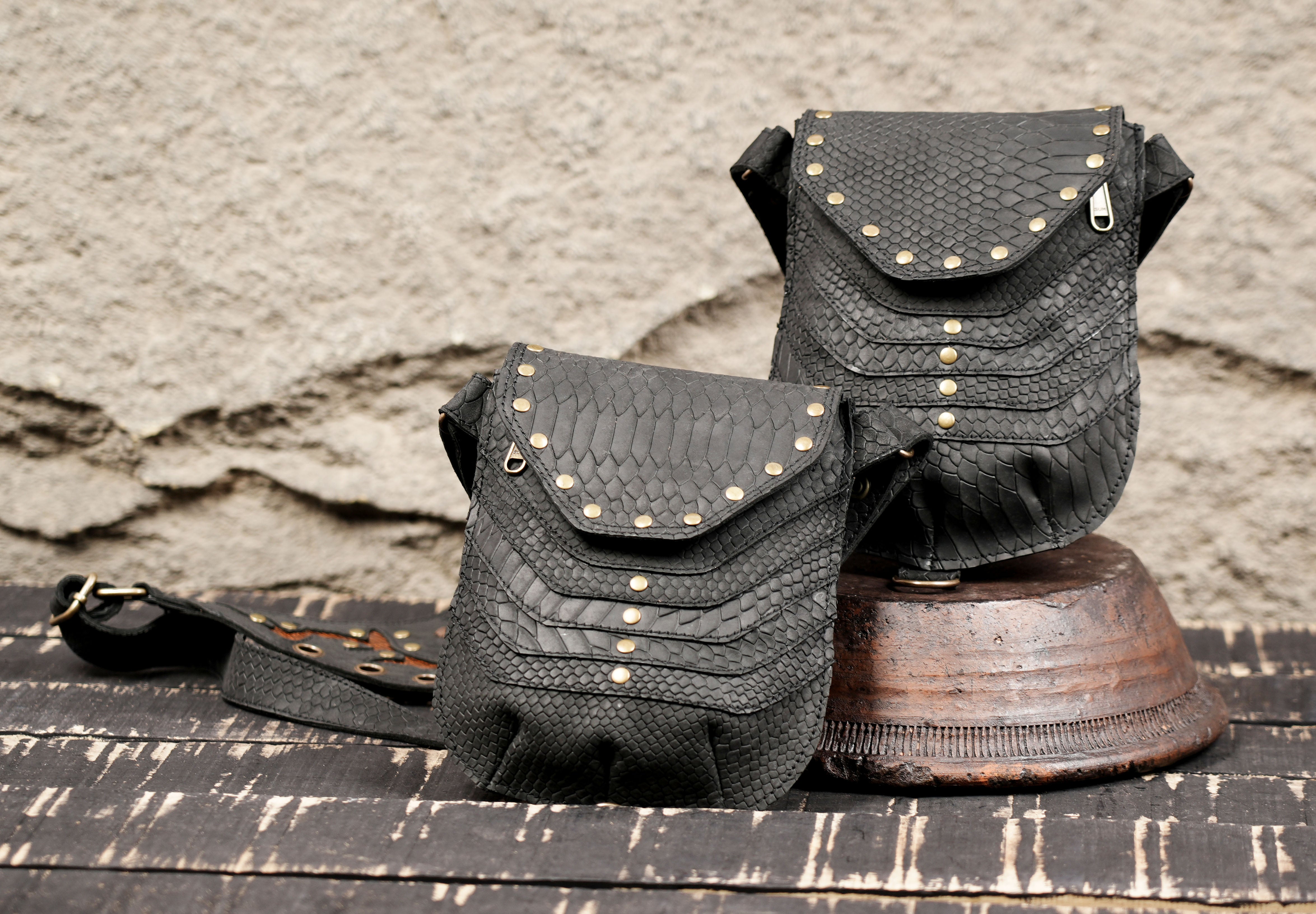 Adjustable leather harness bag with decorative eyelets and gemstone center detail