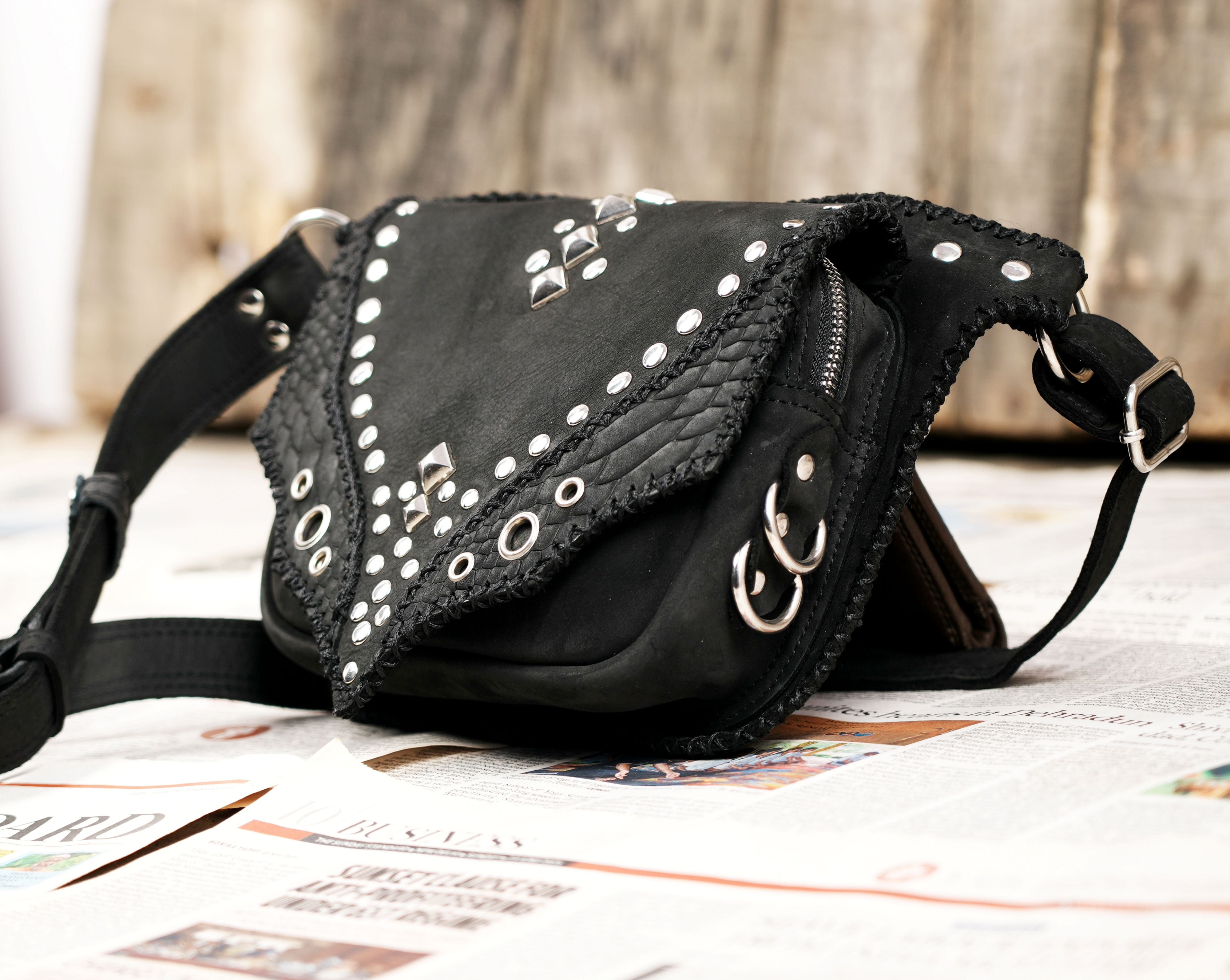 "Leather festival waist bag with decorative studs and textured flap"
