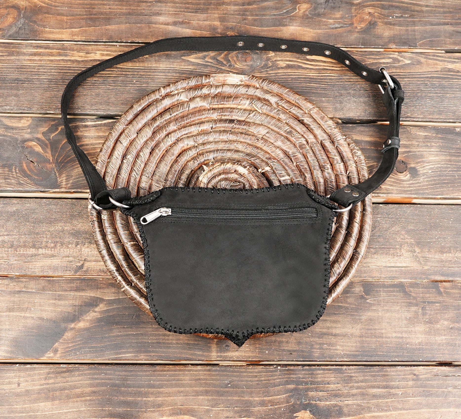"Leather waist bag with decorative metal hardware and textured sides"