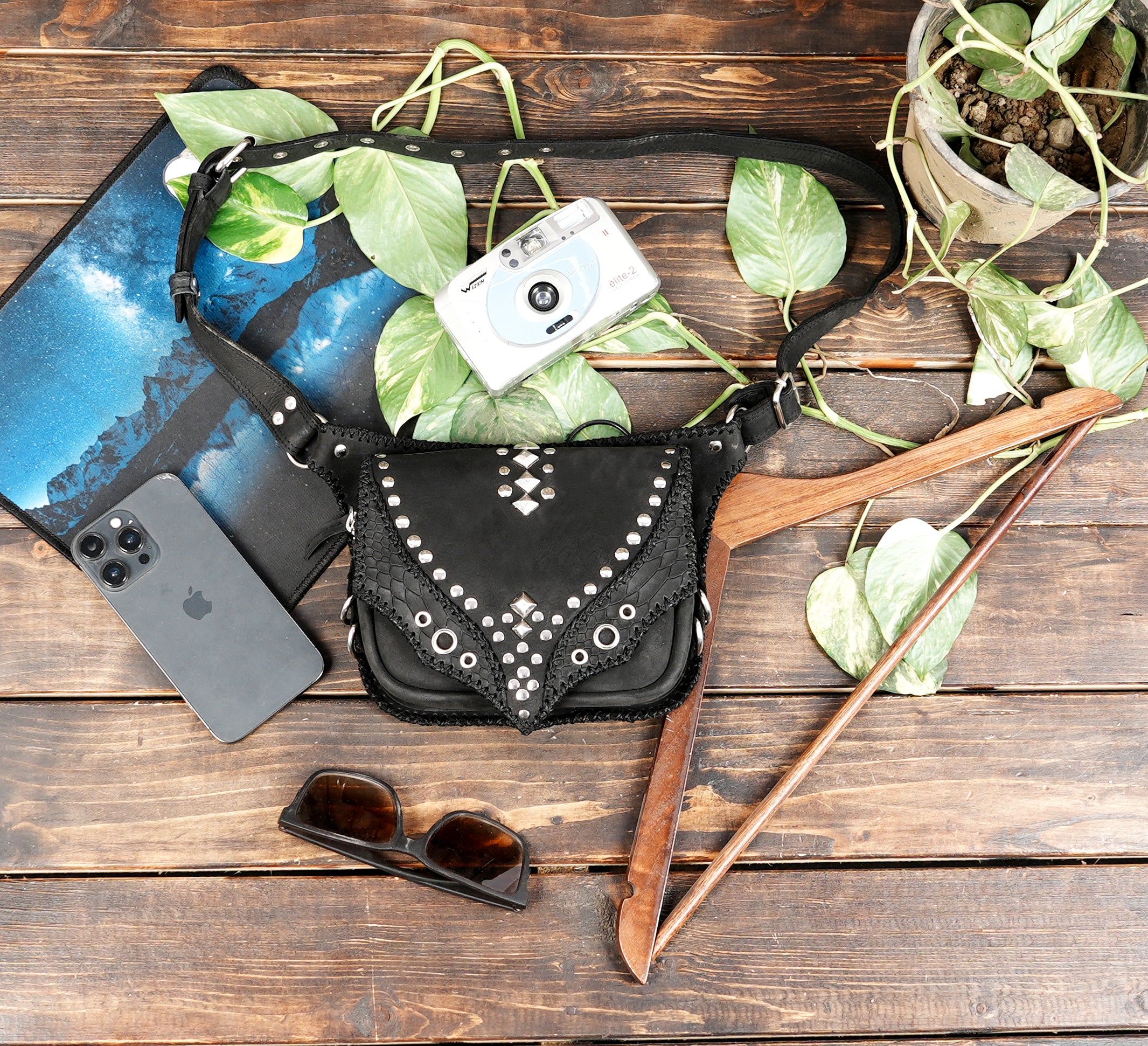 "Black leather hip belt bag with bold rivet patterns"