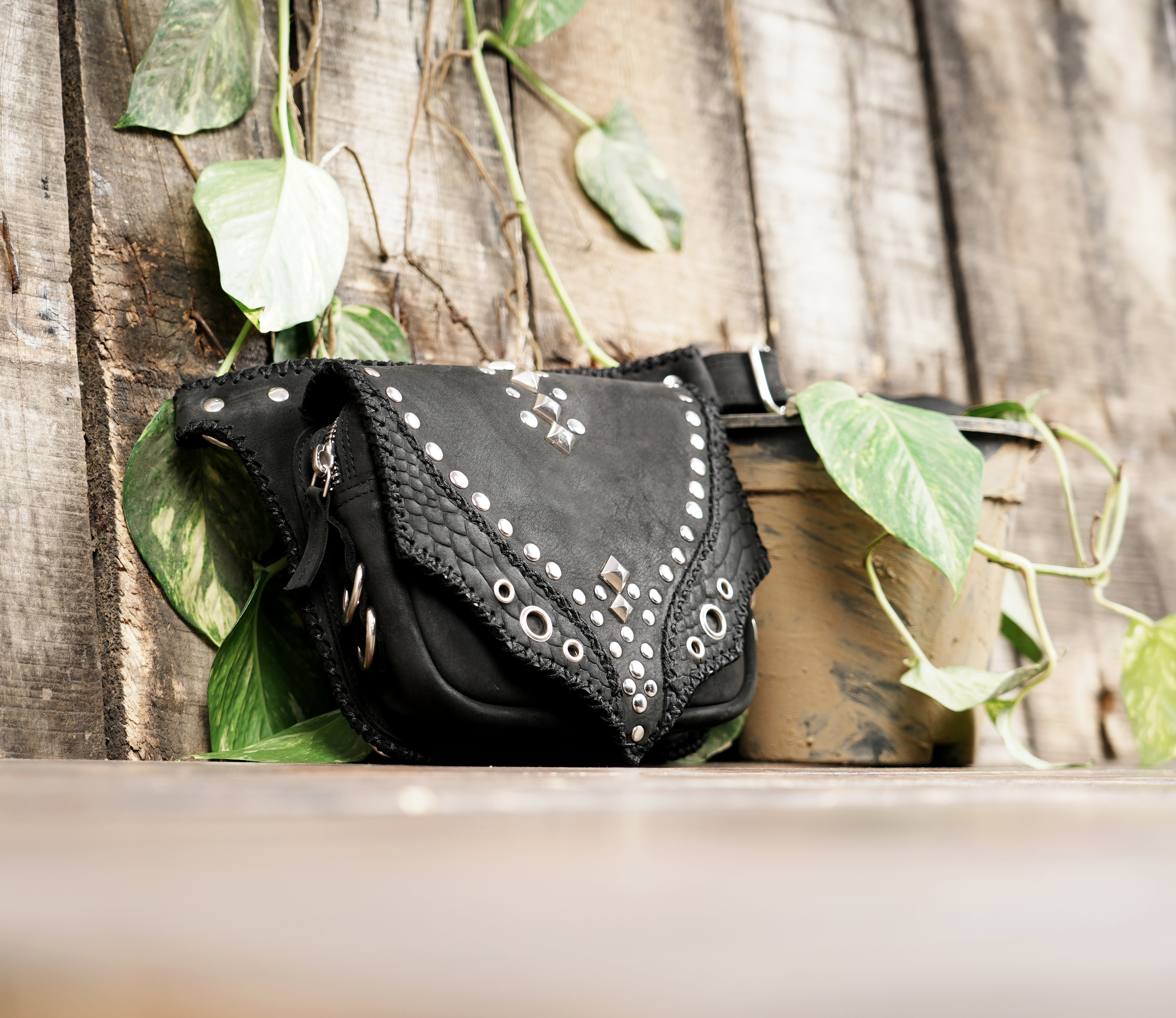 "Black handcrafted leather hip bag with adjustable buckle strap"