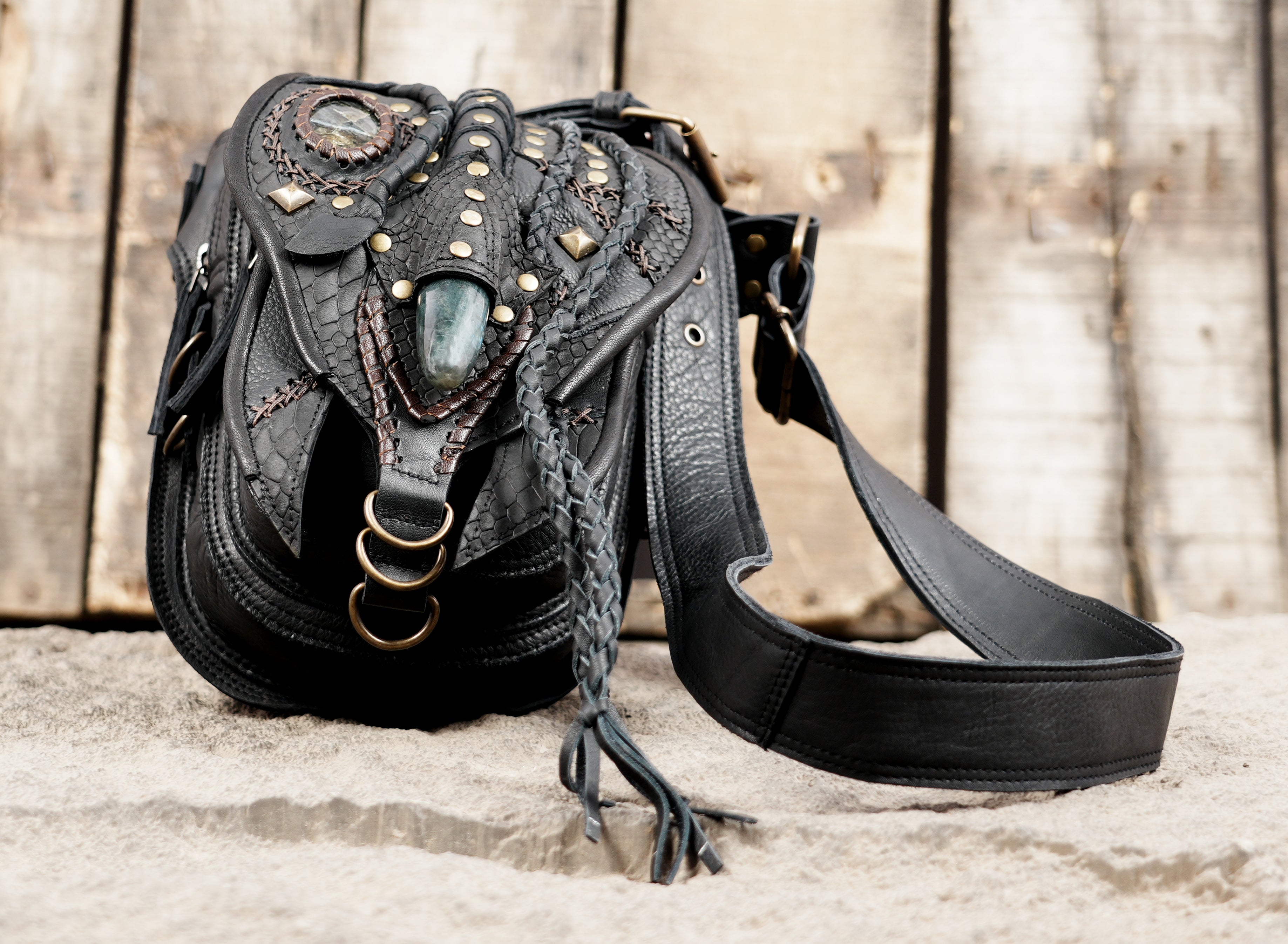 "Black leather tribal-inspired waist pouch with gemstone inlay"