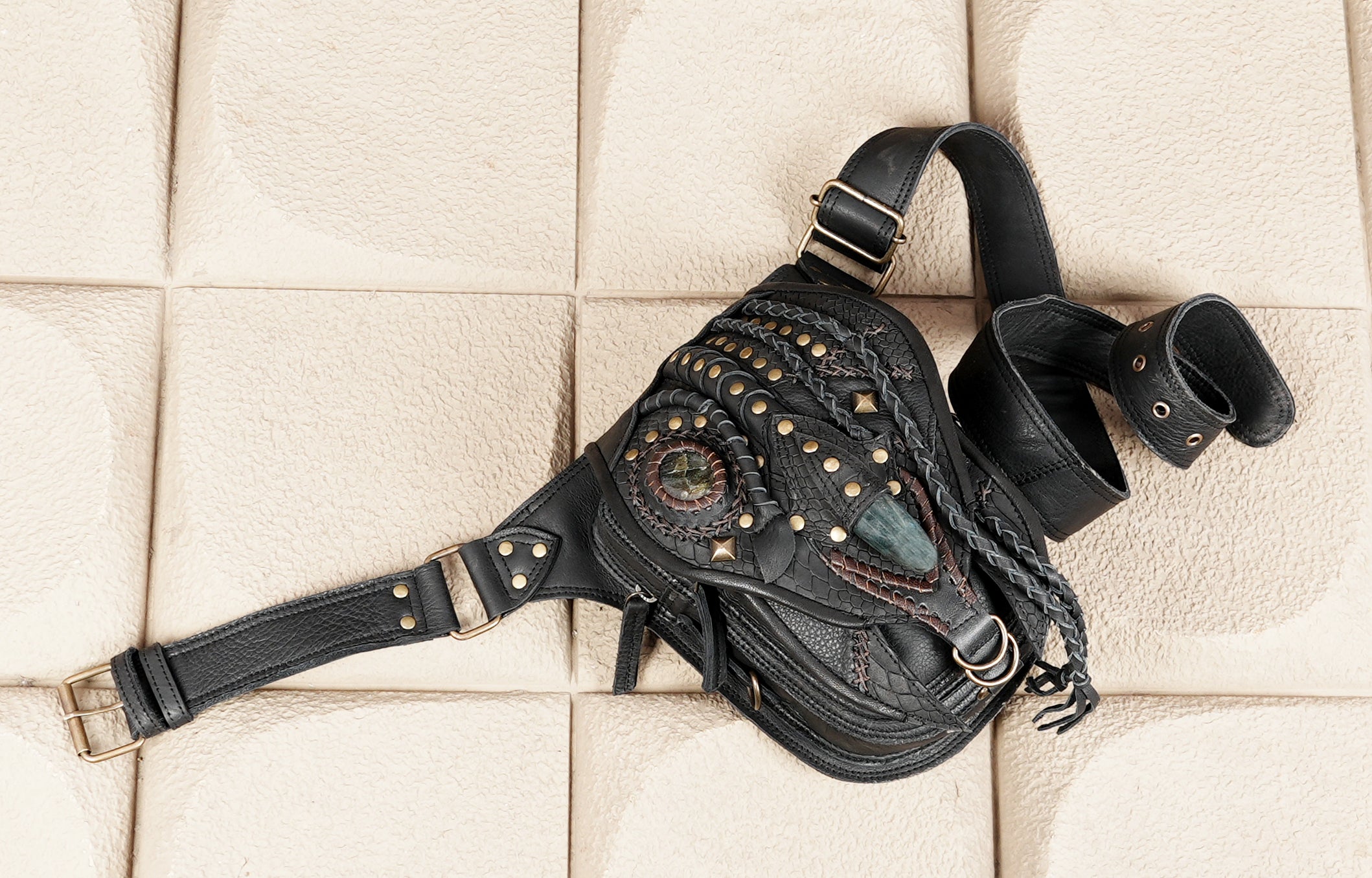 "Boho leather waist bag with layered textures and metal hardware"